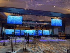 Multiple LED screens serving as a backdrop at a concert venue.